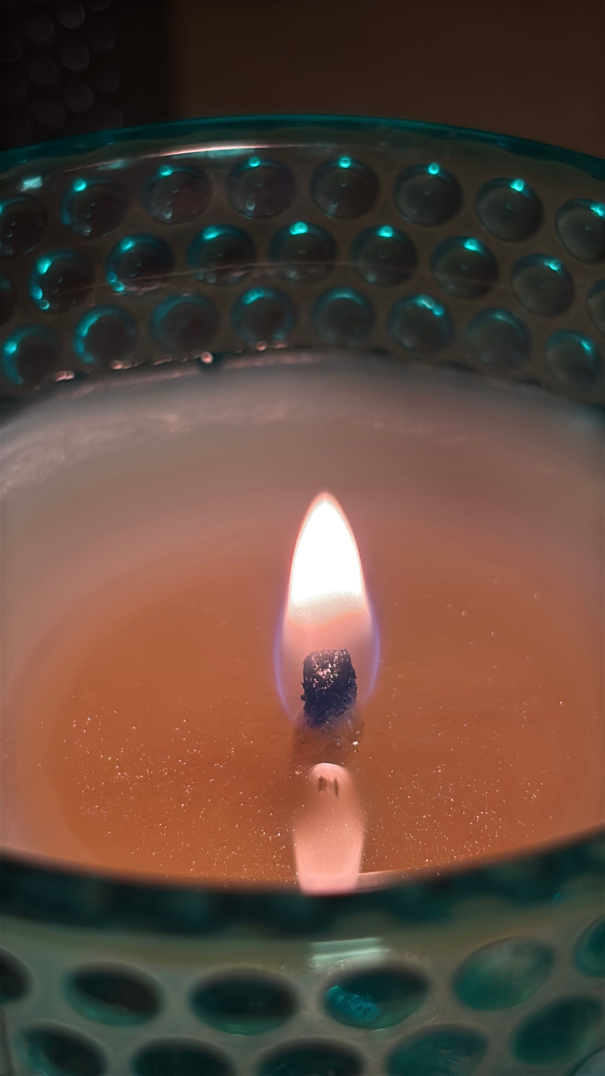 Chama de uma vela acesa dentro de um pote de vidro